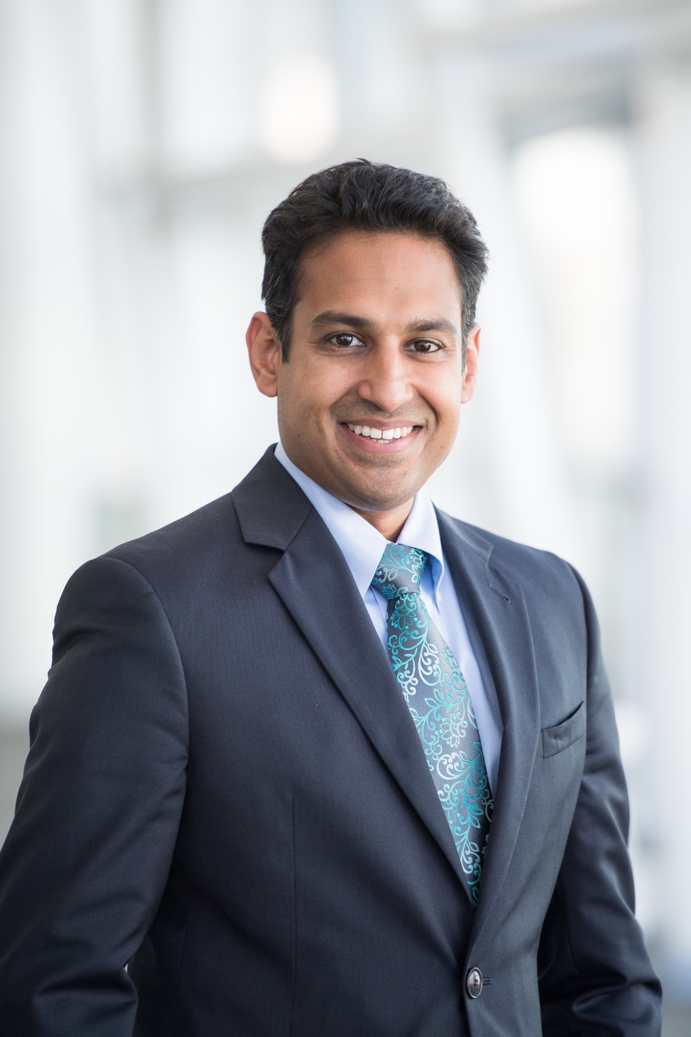 Akash Patel, MD, smiling in a navy suit